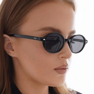 Classic vintage oval sunglasses with black frames and silver rivets shown on a model