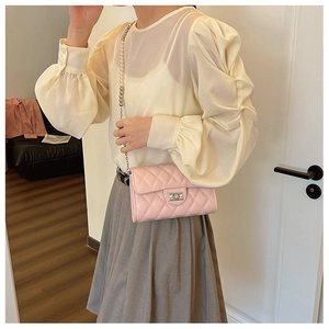 Détail du sac à bandoulière matelassé rose avec chaîne en perles et fermoir rotatif argenté