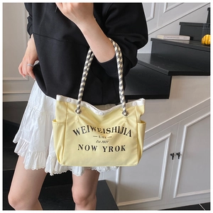 Détail du sac cabas en toile jaune avec anses en corde à carreaux noir et blanc