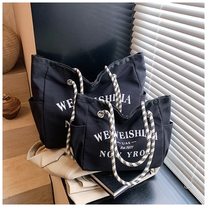 Vue détaillée de grands et petits sacs fourre-tout en toile noire avec poignées en corde