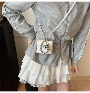 Mini white crossbody bag with silver heart chain accessory and litchi texture finish