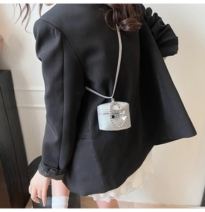 Silver mini bucket bag in lychee leather featuring heart chain detail and shoulder strap