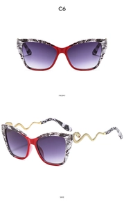 Détail de lunettes de soleil œil-de-chat avec branches dorées en forme de serpent