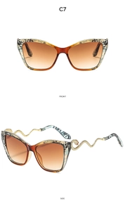 Détail de lunettes œil de chat montrant la monture ambre et les branches serpent doré