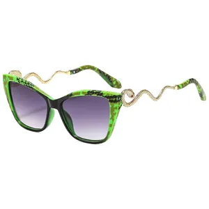 Lunettes de soleil œil-de-chat à monture écaille verte et branches serpent en métal doré