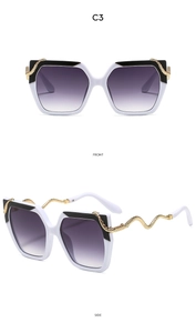 Detail view of square sunglasses featuring black and white frame with gold snake temples