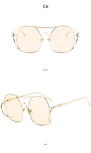 Close-up of golden metal frame sunglasses with light tea lenses and double bridge design