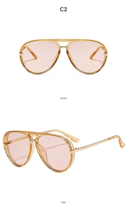 Detail view of aviator sunglasses in amber frame with pink lenses and metal accents