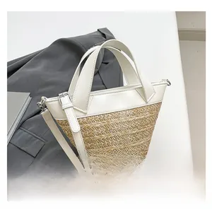 Close-up of woven straw and leather bucket bag with silver hardware and adjustable strap