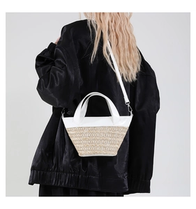 Detail of a mini bucket bag featuring white leather and woven straw texture on a model