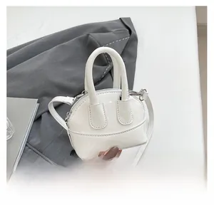 Gros plan sur le sac coquillage en cuir verni blanc avec finition miroir brillante
