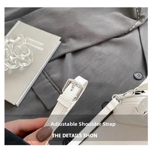 Détail d'une bandoulière réglable en cuir blanc avec boucle argentée sur un sac à main