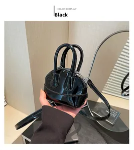 Détail du sac bandoulière noir verni forme coquille avec double poignée ronde