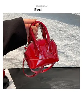 Détail d'un sac à main rouge en cuir verni brillant avec une fermeture éclair argent