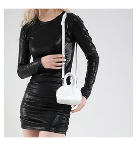 Gros plan d'un mini sac en cuir verni blanc avec fermeture éclair métallique et poignées