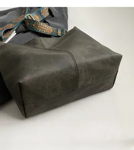 Close-up of the reinforced stitched bottom and textured leather of the tote bag