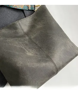 Detail of taupe tote bag with ethnic embroidered strap and fine stitching on fabric