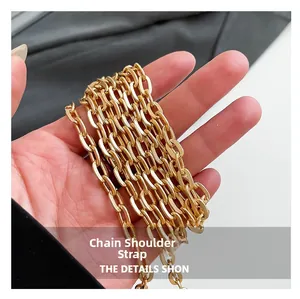 Close-up of a polished gold metal chain shoulder strap for an elegant evening bag