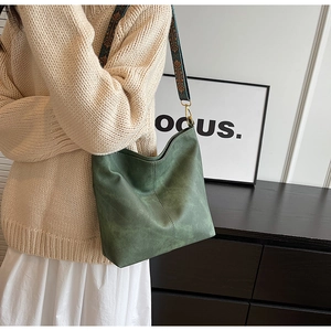 Détail du sac cabas en daim vert foncé avec bandoulière ethnique imprimée