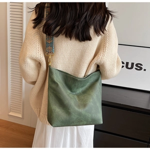 Détail du sac hobo vert vintage avec bandoulière tissée bohème et boucles dorées
