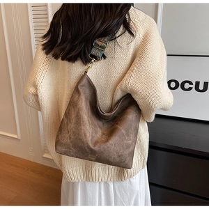 Macro detail of brown vintage hobo bag with ethnic jacquard strap and matte texture