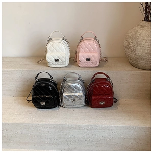 Quilted mini backpacks in five colors with metal chain straps on a minimalist display