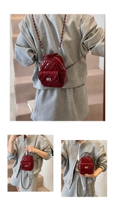 Detail of burgundy quilted leather mini backpack with silver chain straps and turn-lock closure