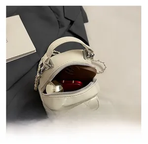 Interior view of quilted cream handbag showing space for phone and makeup items
