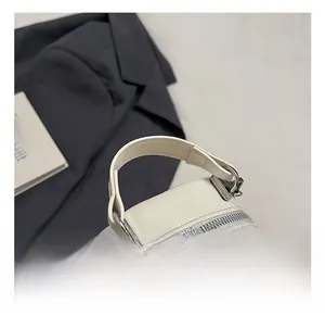 Detail of silver metal handle base and smooth zipper on white quilted leather bag