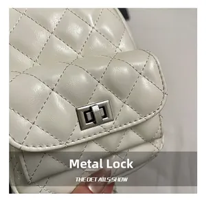 Detailed shot of the silver metal turn-lock and quilted stitching on the beige bag