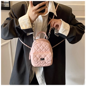 Close-up of pink quilted stitching and metal twist lock on a mini fashion backpack