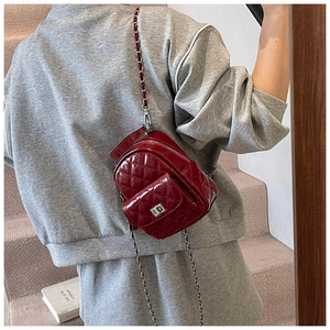Detail of burgundy quilted leather mini backpack with chain strap and glossy finish