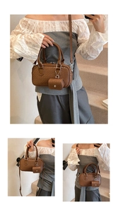 Close-up of brown woven texture Boston bag with gold hardware and mini coin purse charm