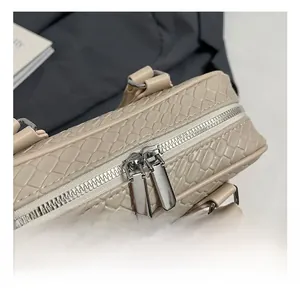 Detail of silver double zippers and woven texture on a beige luxury handbag