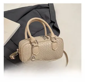 Detail of beige woven bowling bag with twin handles and matching small coin purse attachment