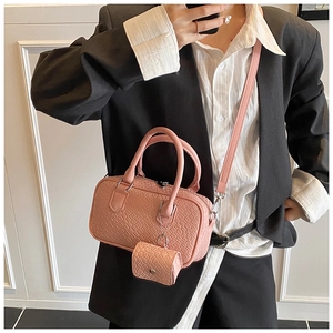 Close-up of pink crocodile texture bowling bag with a mini coin purse on a model