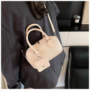 Detail of off-white crocodile embossed crossbody bag and matching small coin purse