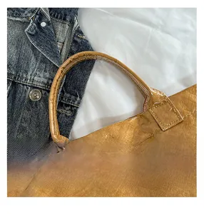 Dettaglio della borsa tote in Tyvek marrone con trama stropicciata unica e manici rotondi
