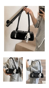Chic black patent leather baguette shoulder bag with cute lace bow ribbon and heart charm.