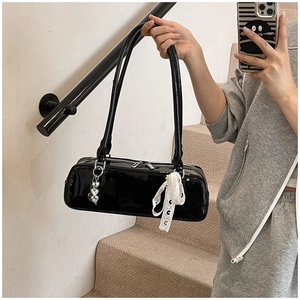 Chic black patent leather underarm shoulder bag with cute bow ribbon and heart charm detail.