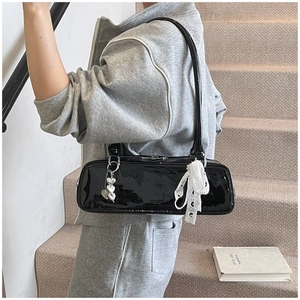 Black patent leather baguette shoulder bag with cute heart charms and white lace bow detail.