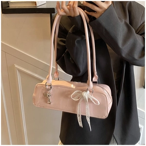 Pink patent leather baguette shoulder bag with white lace bow and cute metal charm pendant detail.