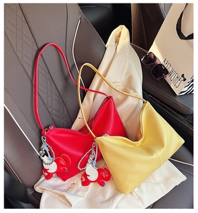 Close-up of yellow and red pebbled leather hobo bags with cute elephant charms