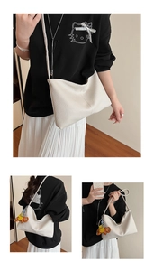 Close-up of off-white lychee grain leather texture and stitching detail on hobo bag