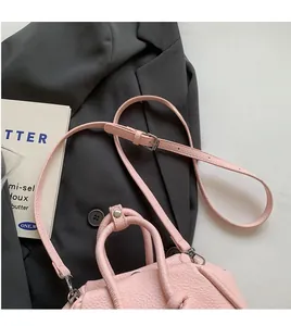 Dettaglio della borsa in pelle rosa con tracolla regolabile e fibbia in argento