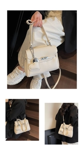Macro detail of lychee grain leather handbag with silver heart pendant and metal lock