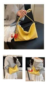 Detail of yellow lychee texture hobo bag with cute red elephant charm and stitching