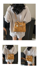 Detail view of brown lychee grain leather Kelly bag with heart pendant and metal lock clasp