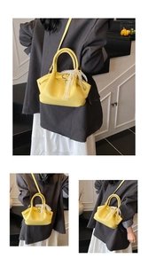 Close-up of bright yellow bucket bag featuring lace bow and pearl bead ornaments