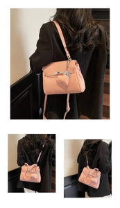 Detail of light pink lychee leather handbag with heart pendant and silver metal lock